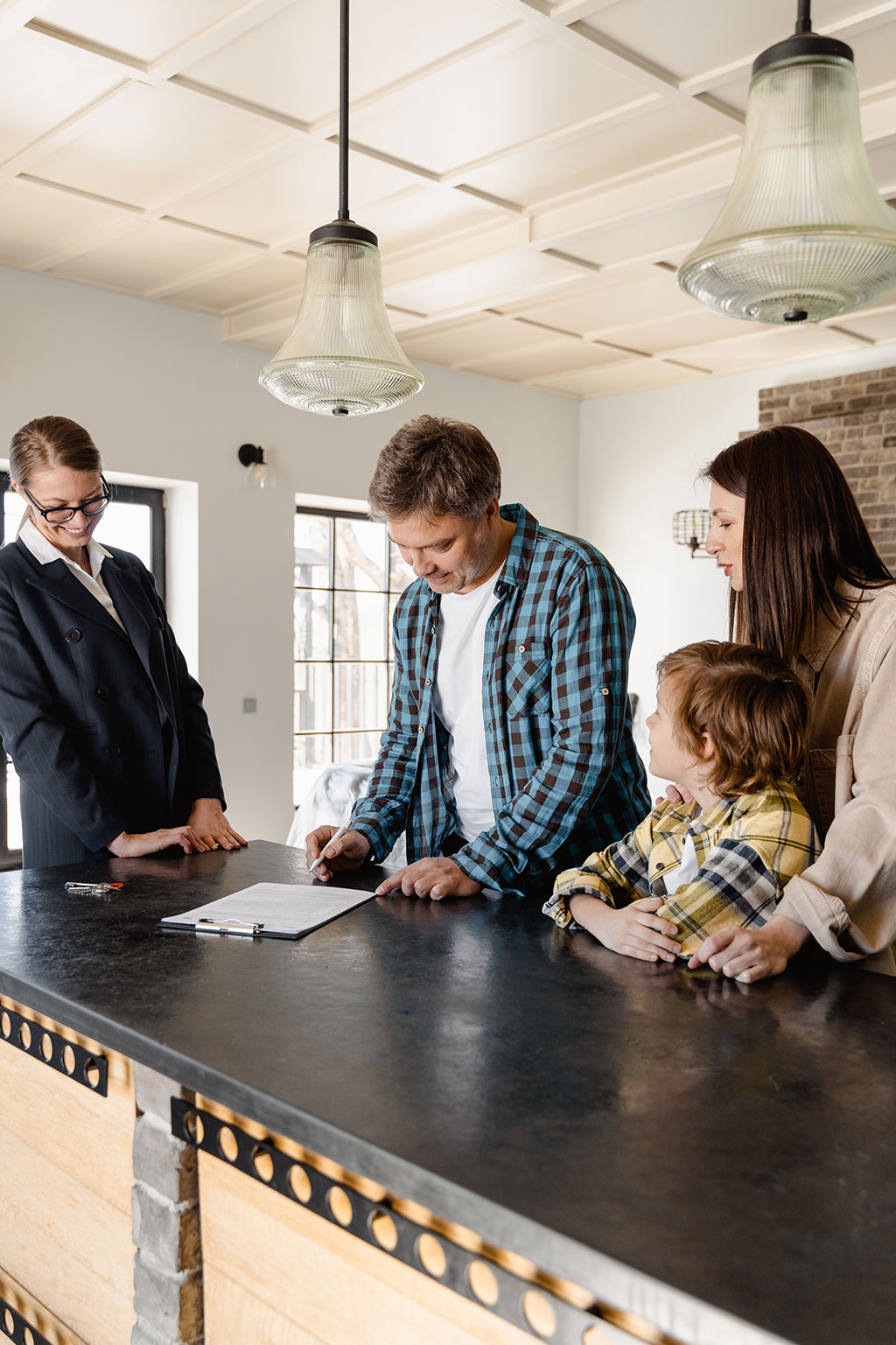 Family with realtor, man signing paper