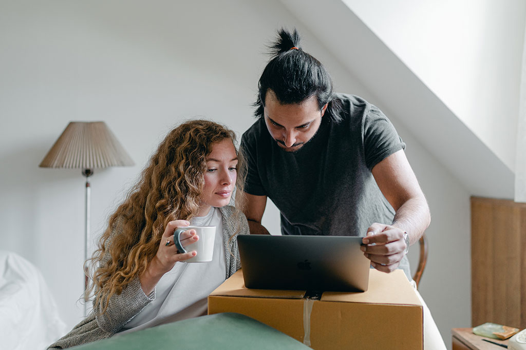 Couple on laptop while packing