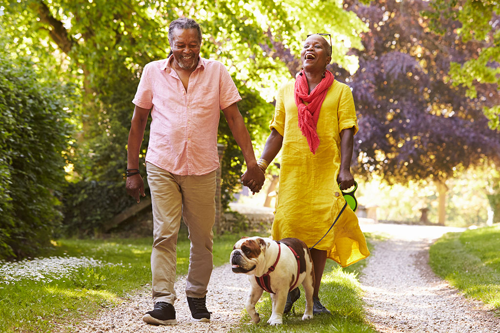 Older couple walking outside with dog