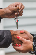 People holding hands and handing off key