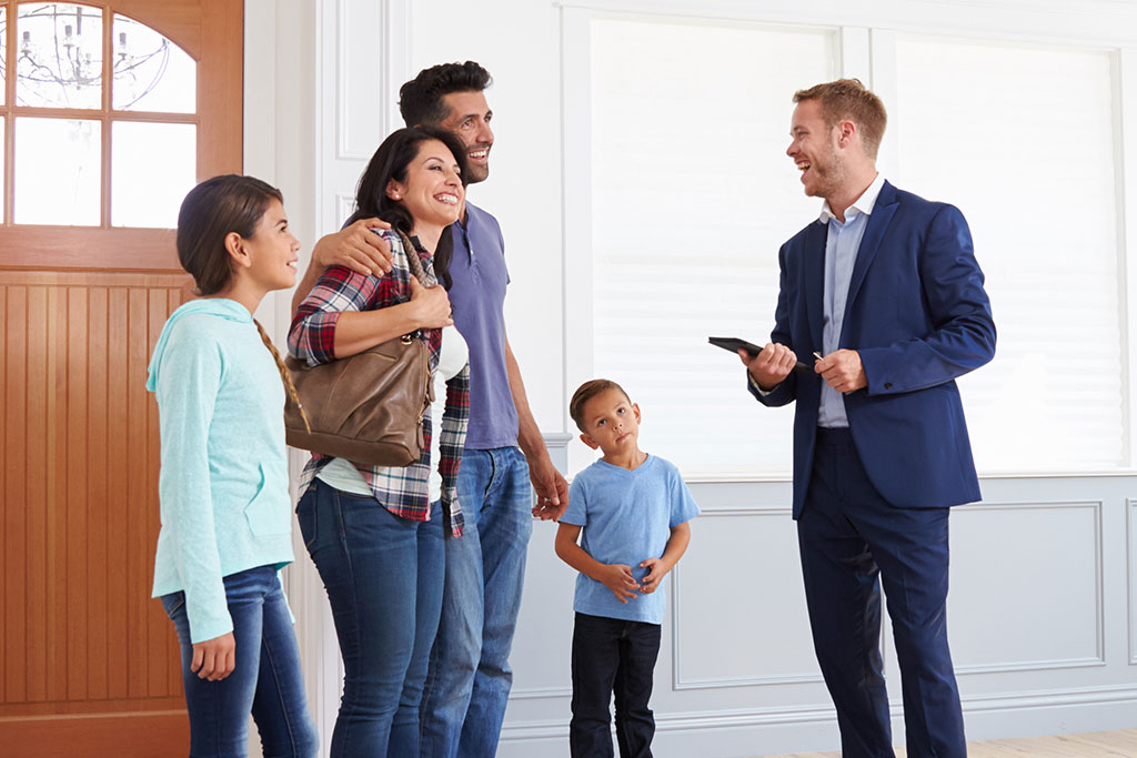 Family talking with a realtor inside a house