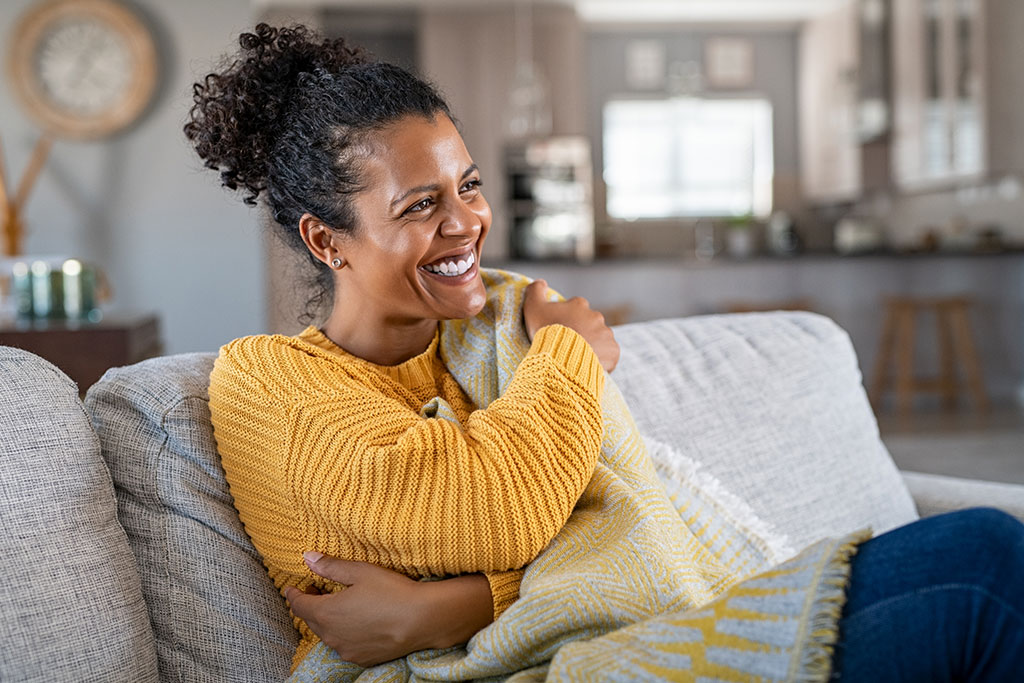 Woman sitting on couch with blanket