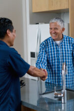 Plumber shaking hands with man