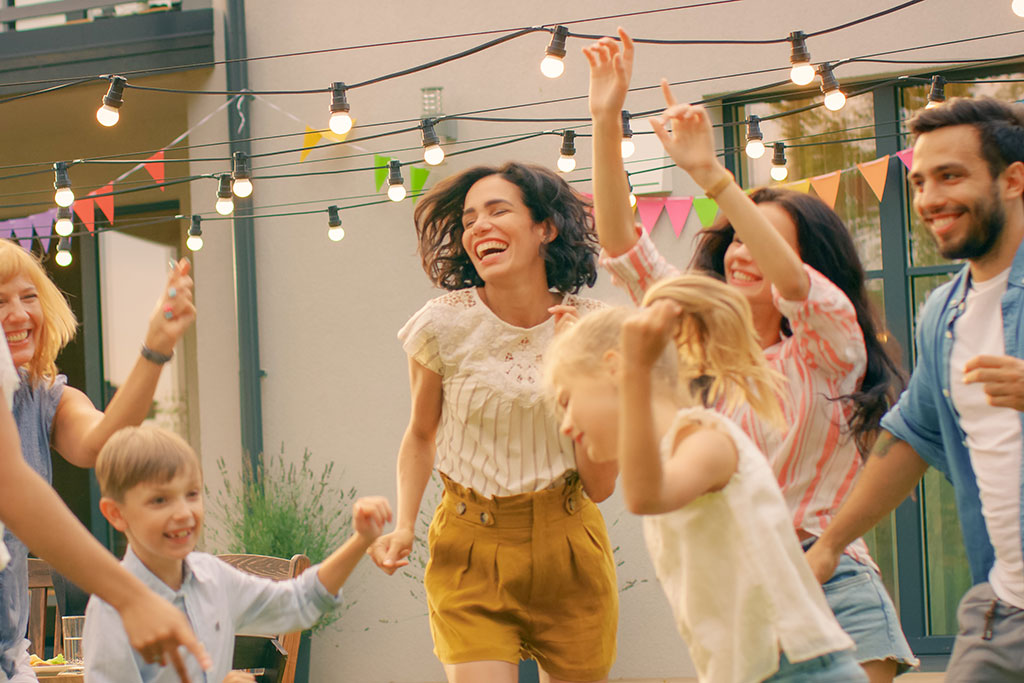 Family dancing outside at backyard party