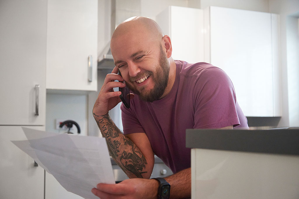 Man on phone looking at papers