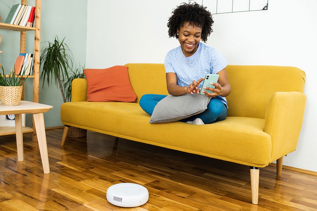 Woman sitting on couch robotic vacuum