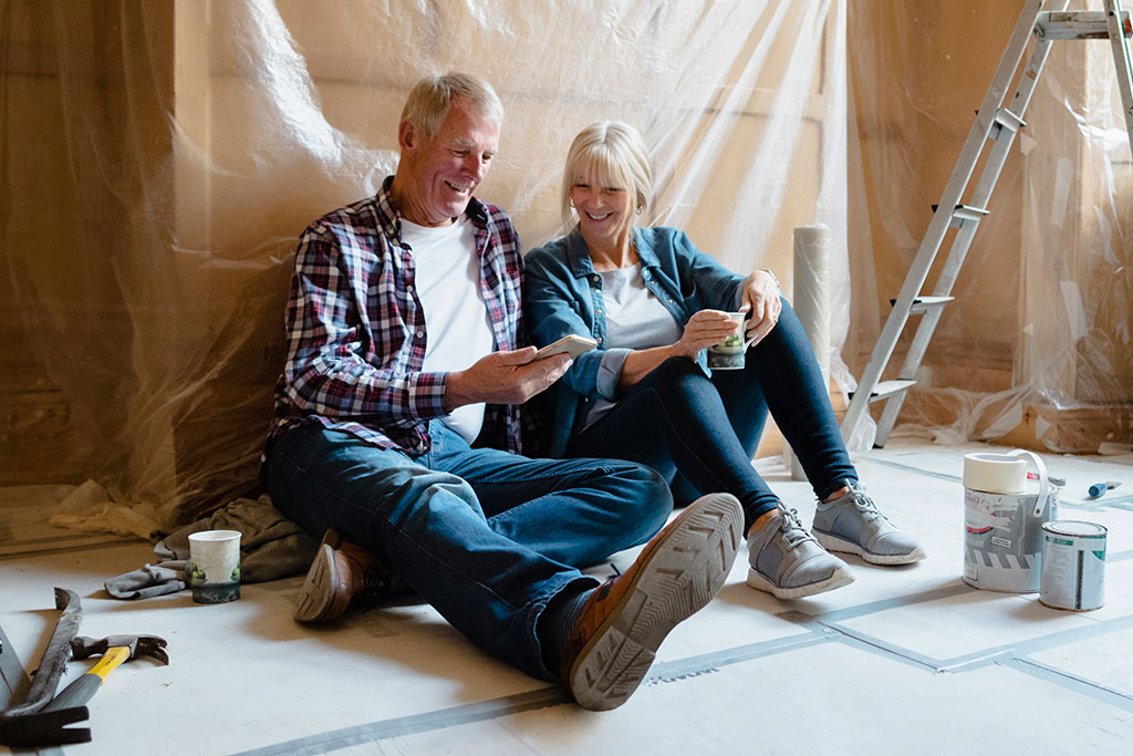 Older couple sitting on floor while house is being renovated