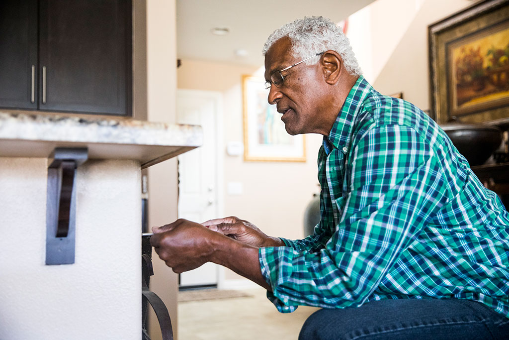 Older man fixing cabinet