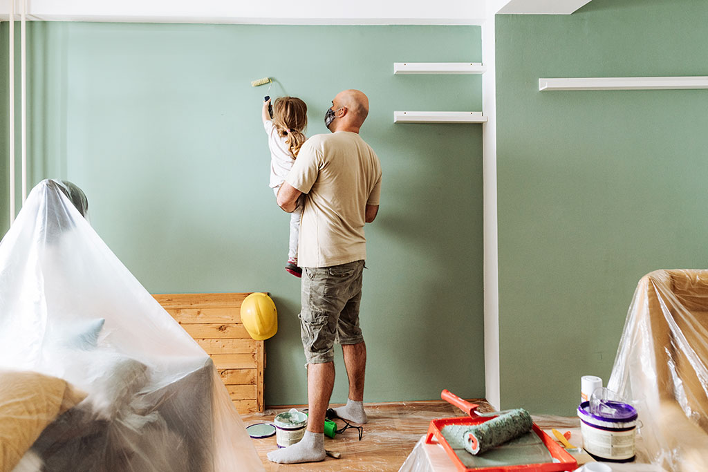 Dad and daughter painting wall