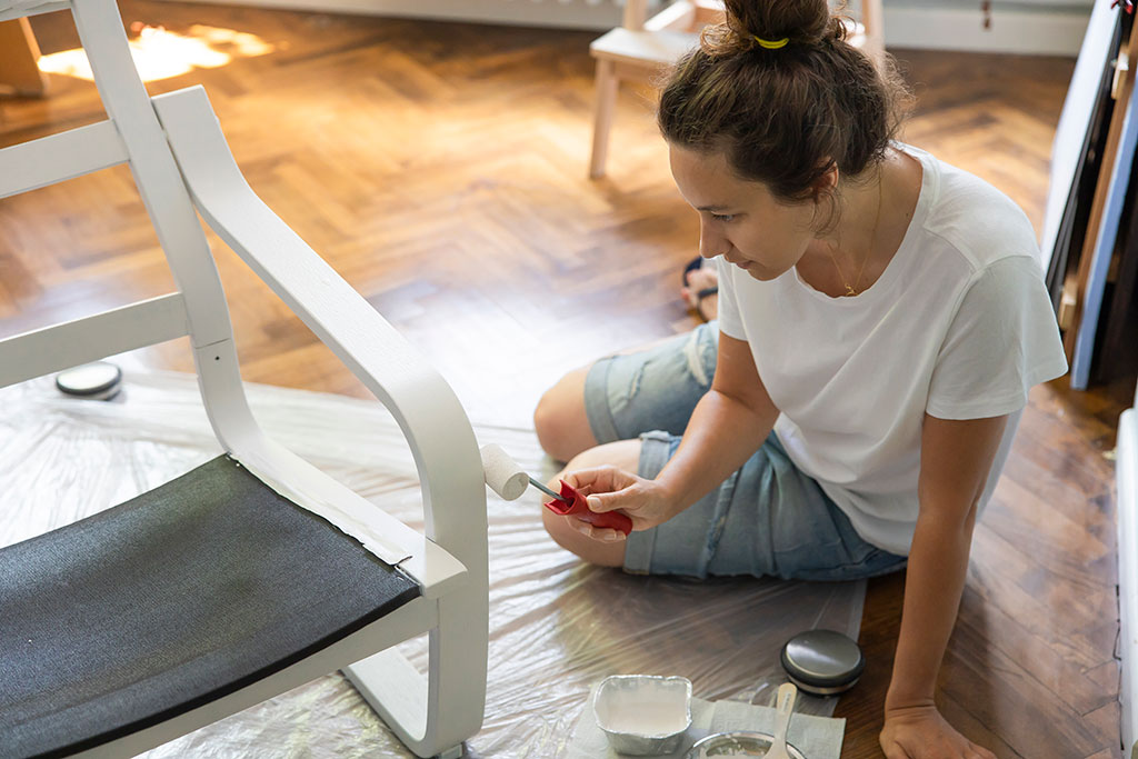 Woman re-painting chair