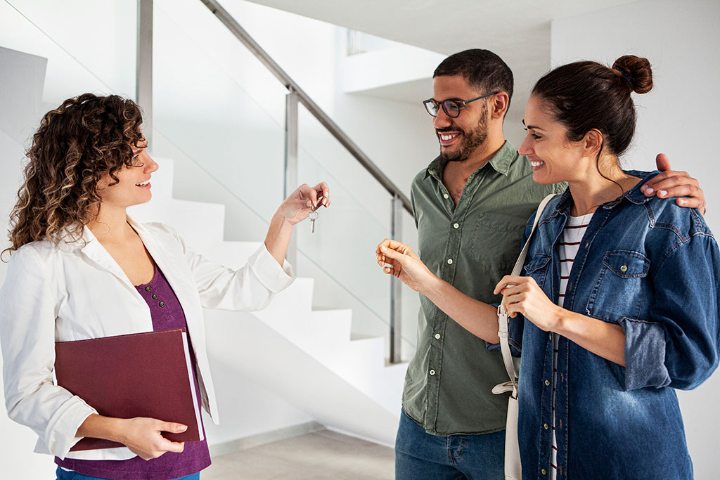 Couple getting keys to new home from real estate agent