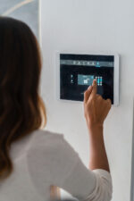 Woman locking house with smart home