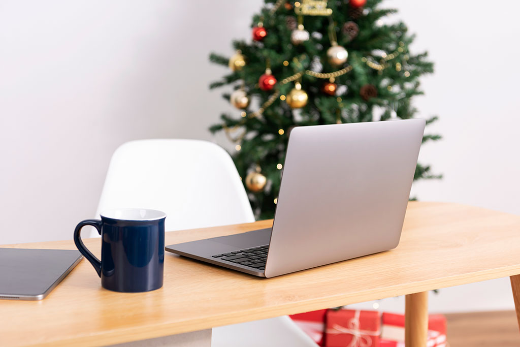 At home office with Christmas tree in background