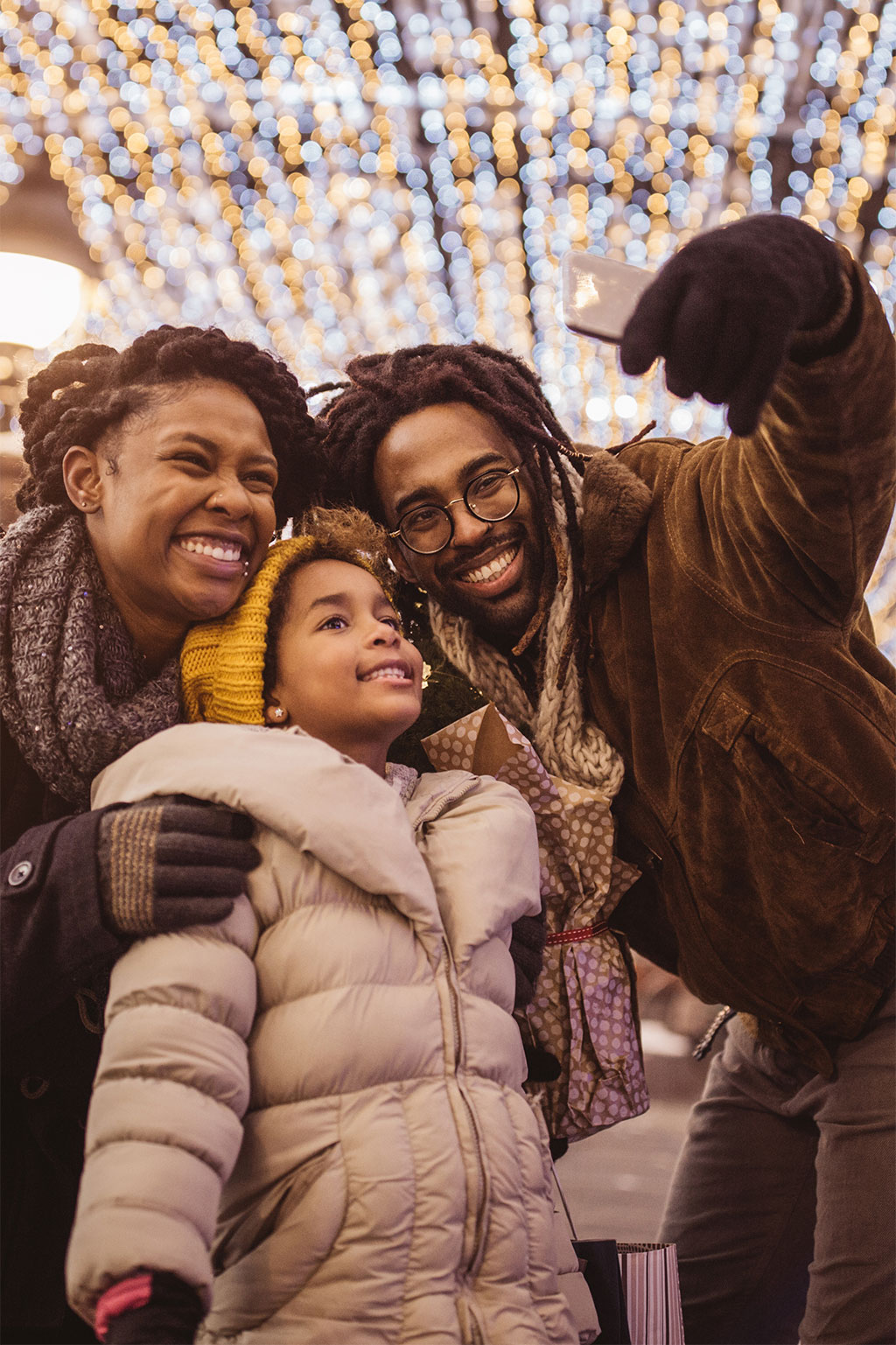 Family taking selfie with Christmas lights