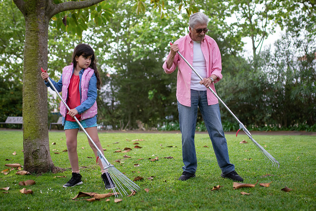 Family raking leaves in yard