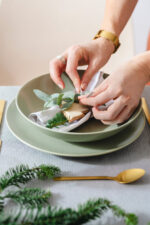 Person fixing dining table plates