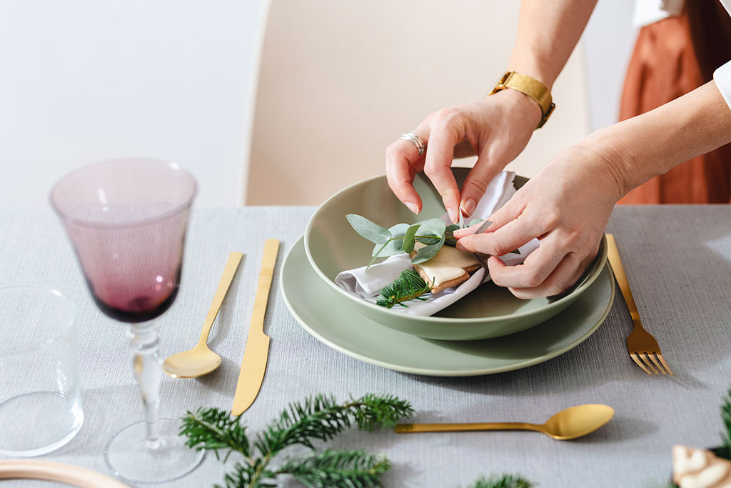 Person fixing dining table plates