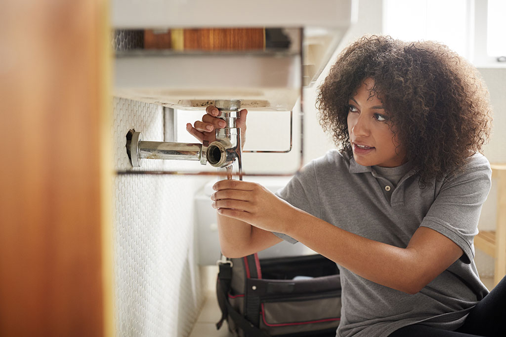 Woman fixing faucet