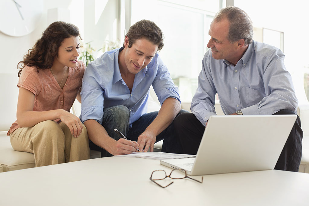 Couple signing papers with realtor