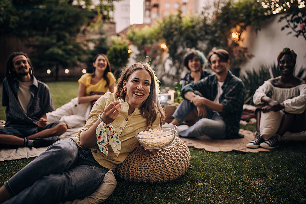 Friends watching movie in backyard