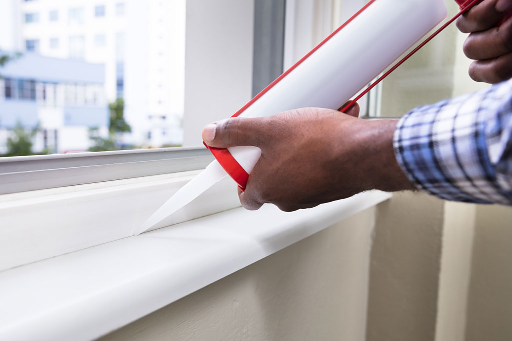 Man caulking window