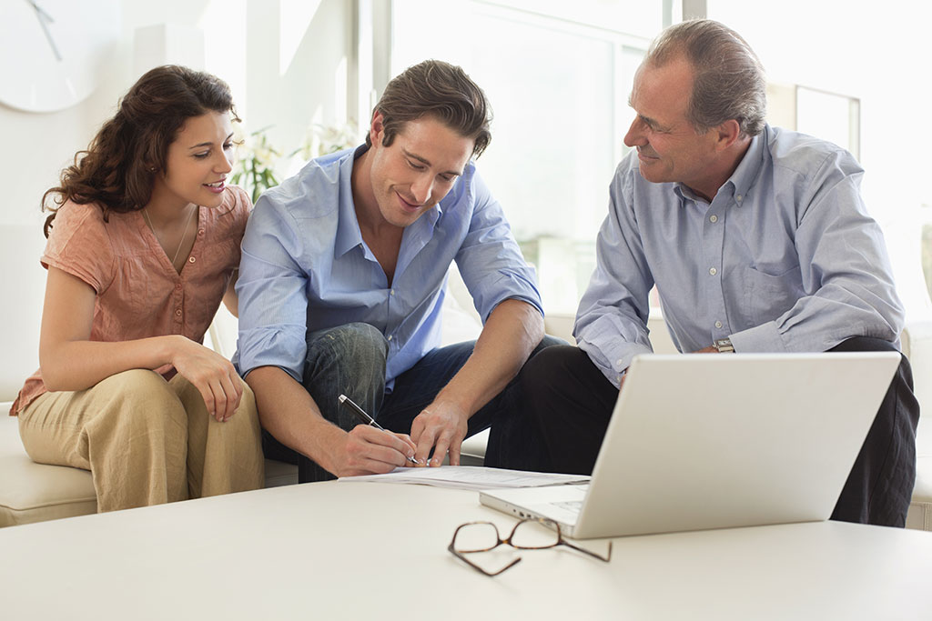 Couple talking to realtor signing papers