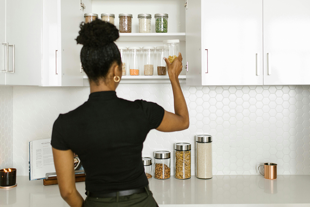 Woman organizing kitchen cabinets